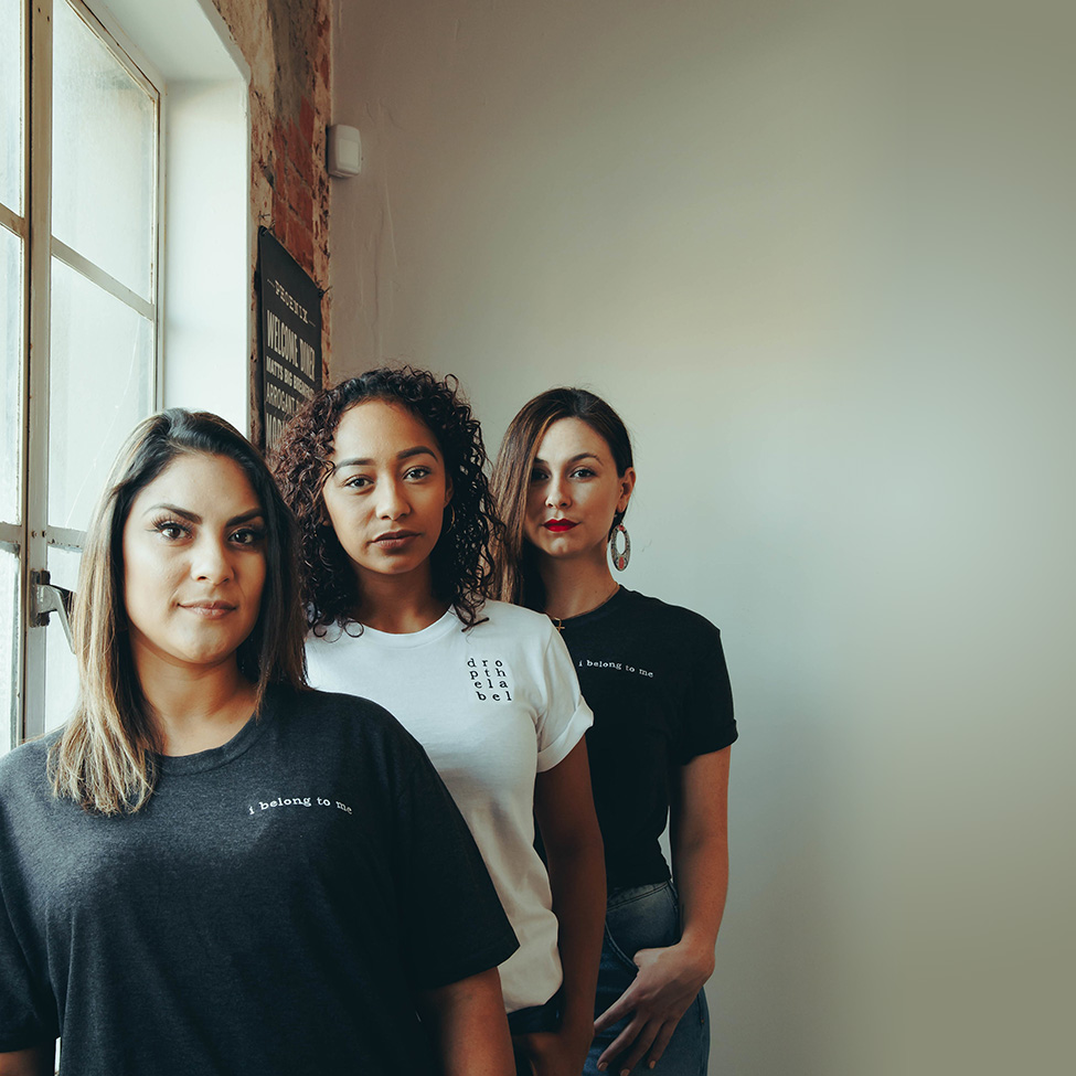 Three strong women wearing shirts that say I belong to me